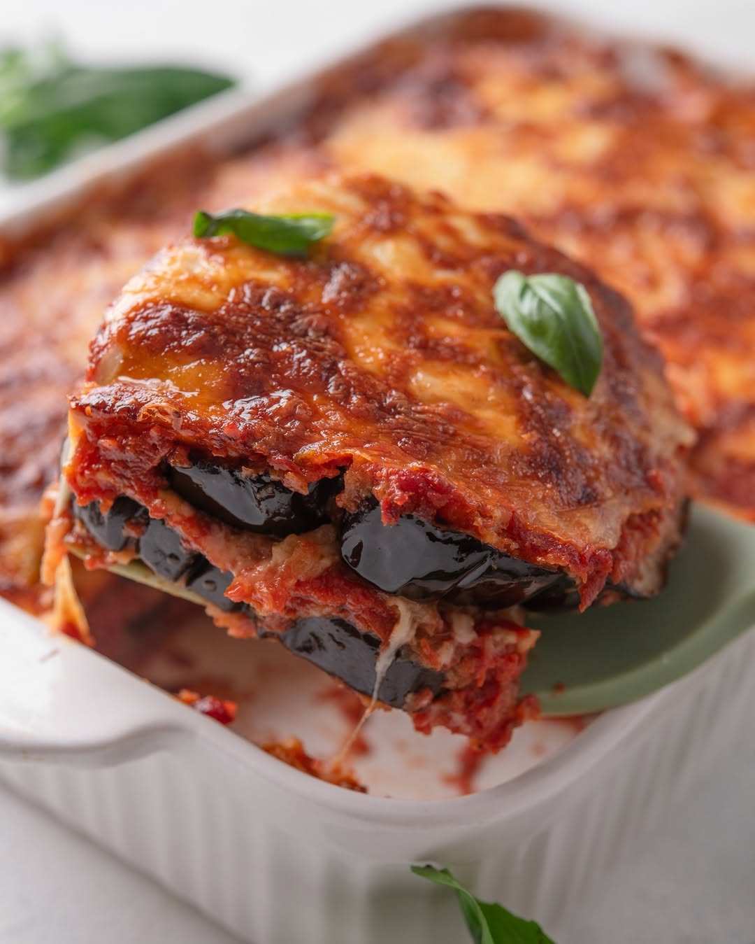 Delicious authentic Sicilian aubergine lasagne with layers of cheese and tomato sauce served in a dish