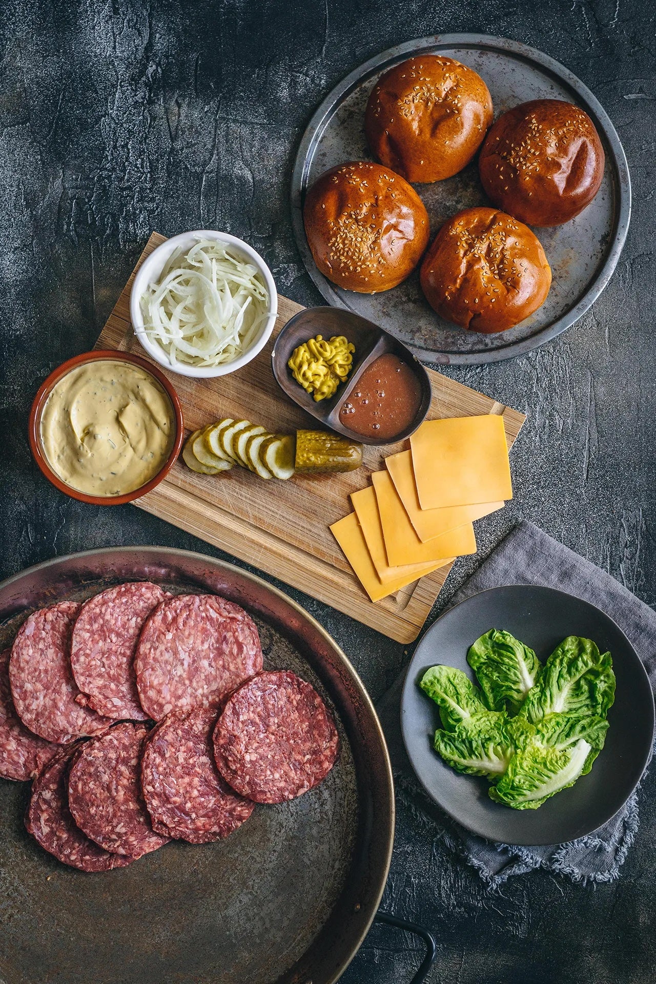 Flayvr gourmet burger kit including patties, buns, cheese, and toppings for a delicious meal