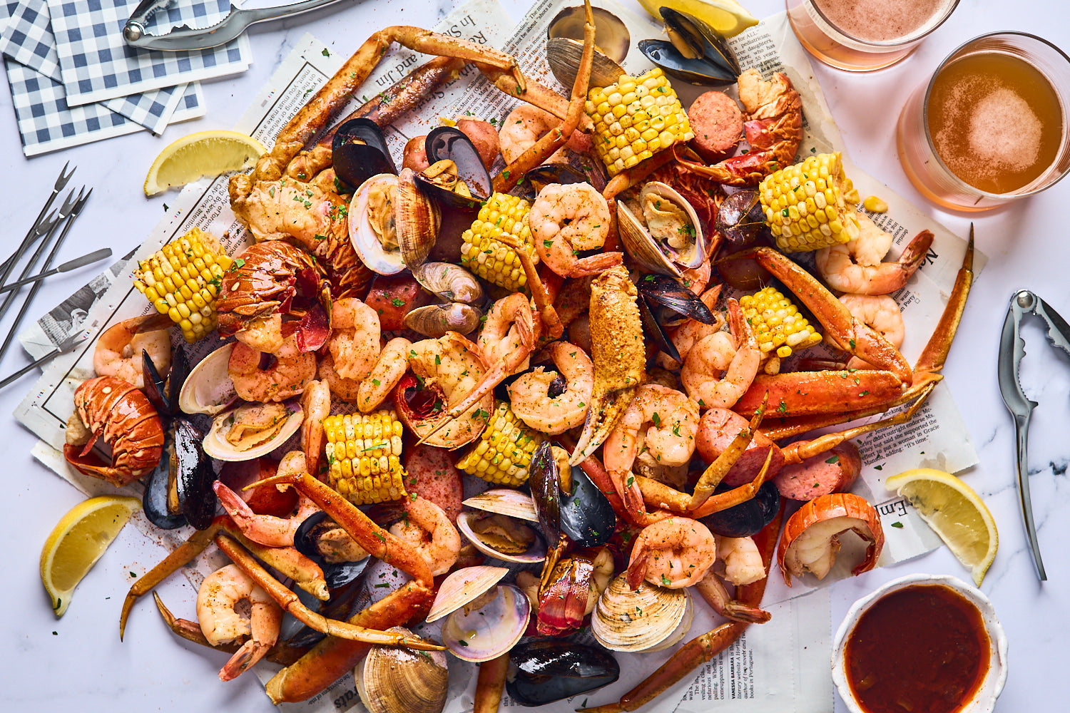 Flayvr Gourmet Seafood Boil Kit with shrimp, crab, corn, and sausage on a festive table