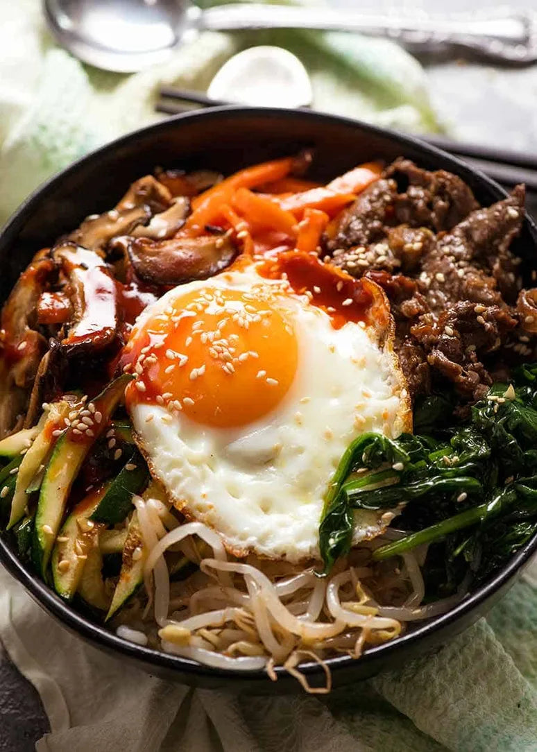 Delicious organic Korean bibimbap kit featuring rice, vegetables, beef, egg, and spicy sauce